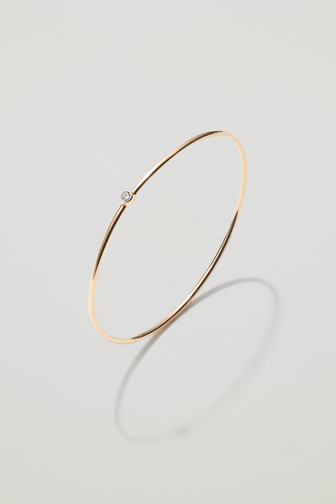 Solid gold bangle with an April diamond birthstone, symbolising love and strength.