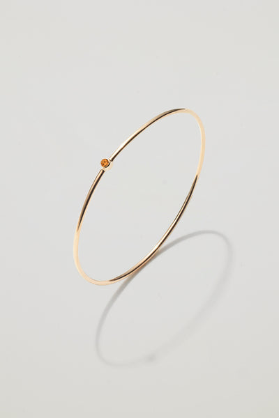 Solid gold bangle with a November citrine birthstone, symbolising joy and abundance.