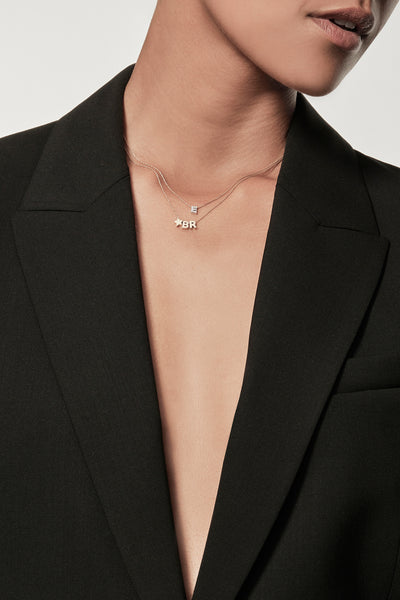 Two layered necklaces featuring three charms: the initials "B" and "R" separated by a small star charm, and a lab-grown diamond initial "E" necklace on a fine chain with an openable connector clasp. The plain white background highlights the simplicity and elegance of this exquisite necklace.