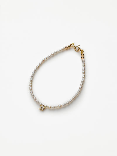 Hand-strung bracelet with natural freshwater pearls and miniature three-dimensional diamond star in 18k solid gold